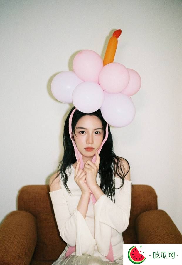 周也身着粉色条纹衬衫，头戴气球宛如梦幻少女