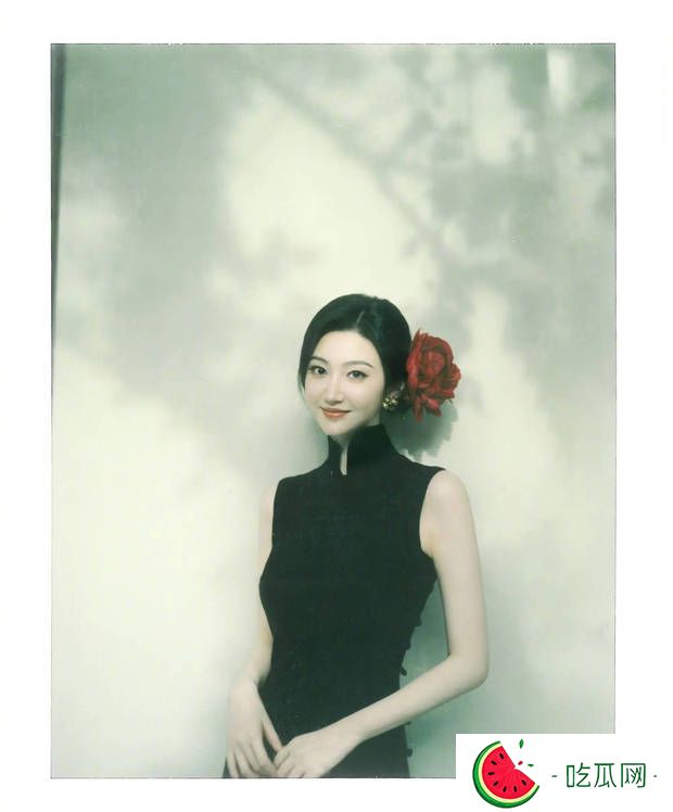 景甜黑色无袖旗袍裙撕拉片，头戴大红花演绎复古明艳风